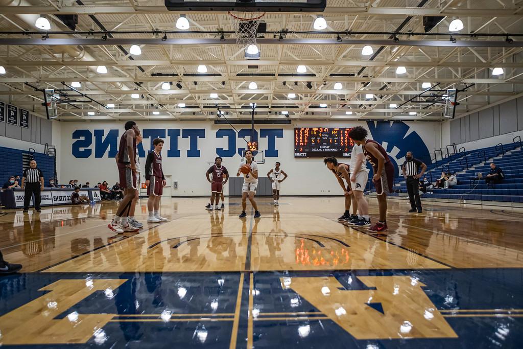 a wide shot of the main athletics gym, picturing students playing basketball